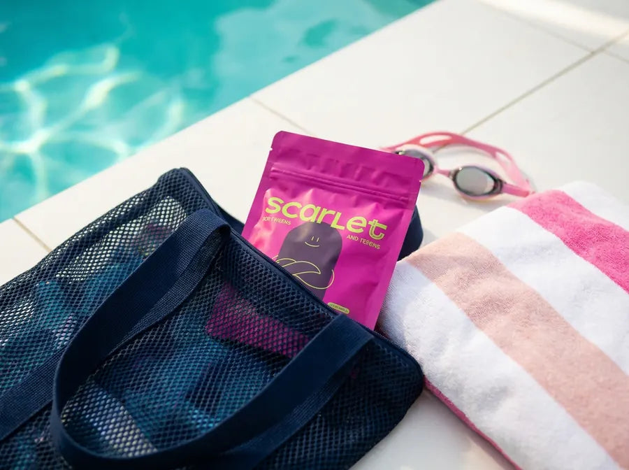 Scarlet X-Small tampons in a mesh swim bag on the pool deck