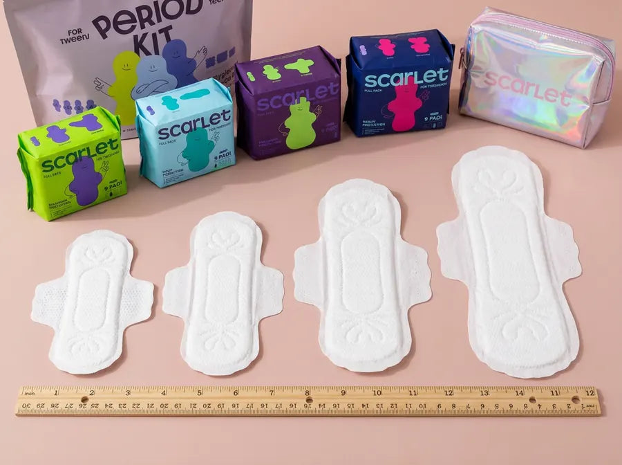 Four white Scarlet pads on a ruler with their packs