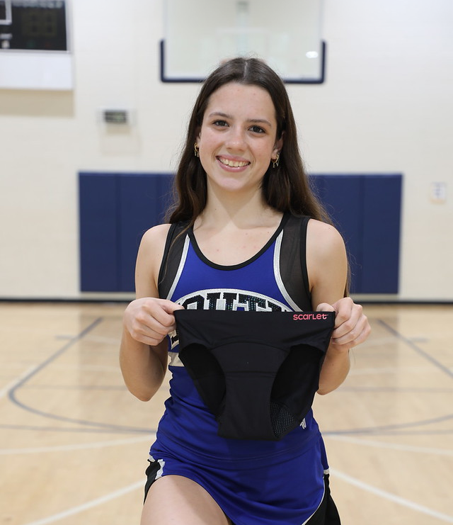 Scarlet period underwear held by a teen athlete
