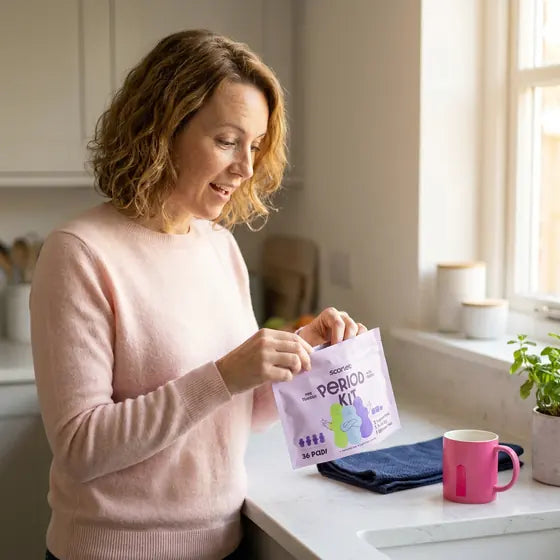 The mom opening the Scarlet Period Kit pouch in her kitchen